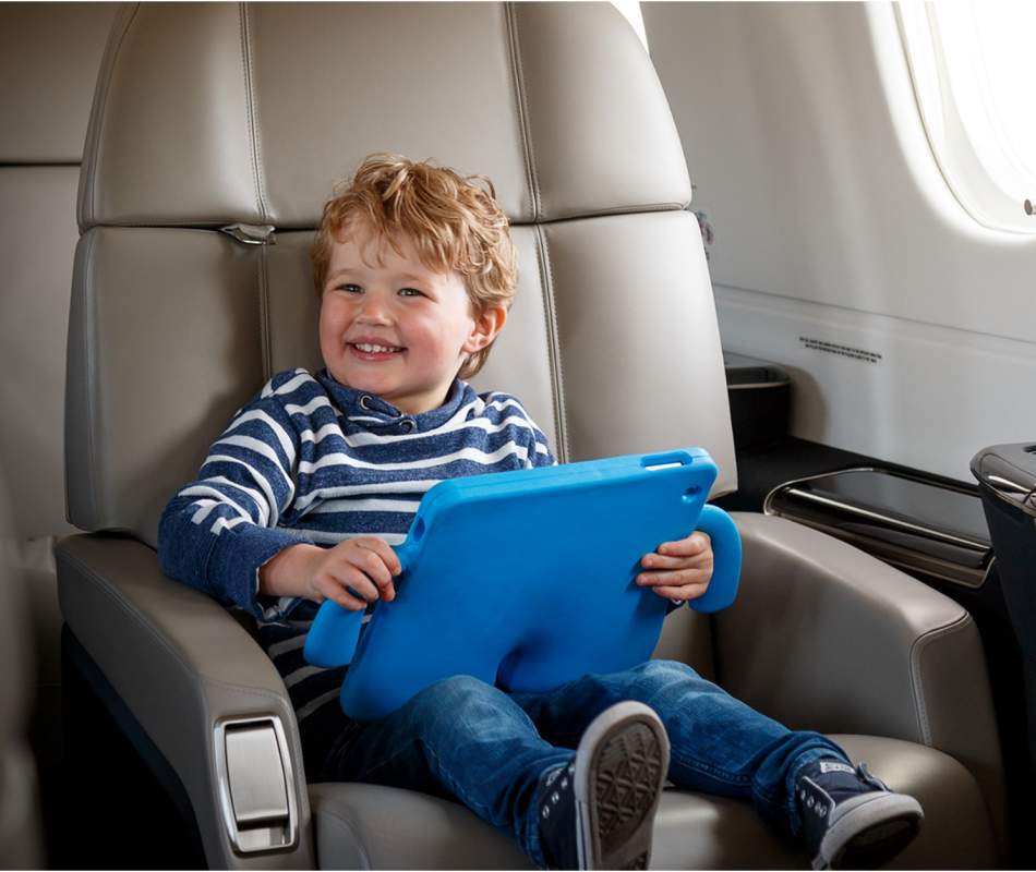 kid smiling in an AirSprint Legacy 450 plane