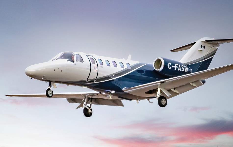AirSprint Citation CJ2+ flying over cotton candy skies