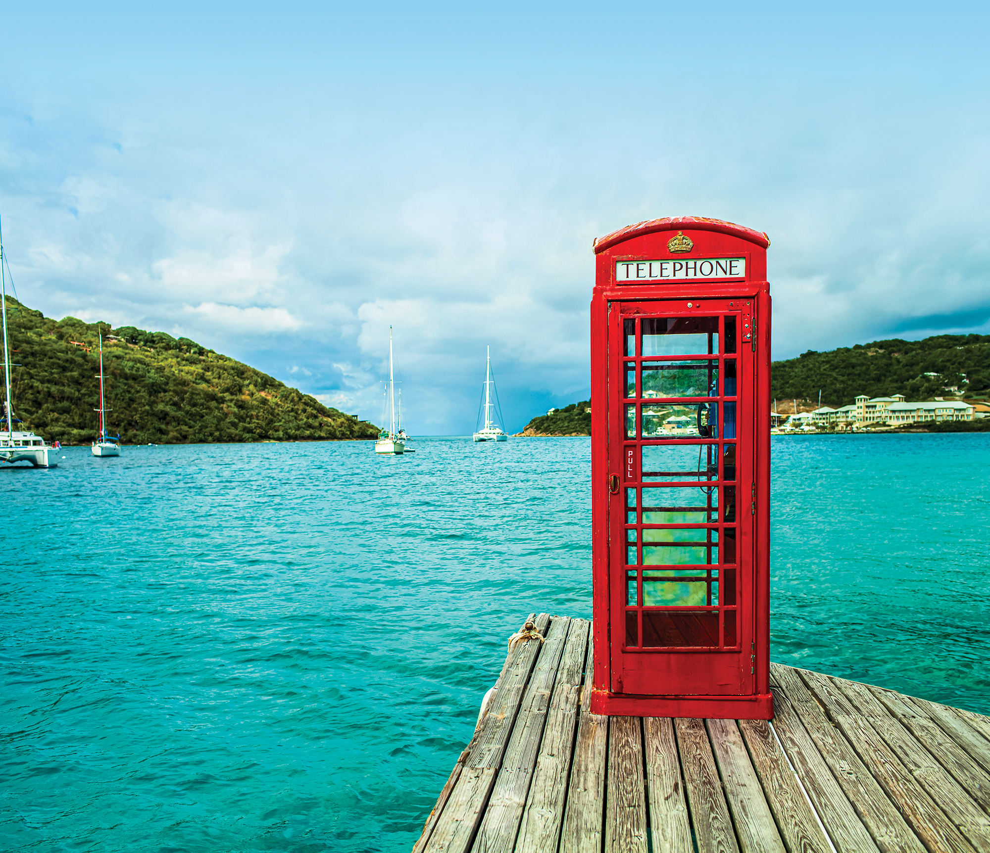 Red telephone booth overlooking the sea and mountainous landscape of the British Virgin Islands.